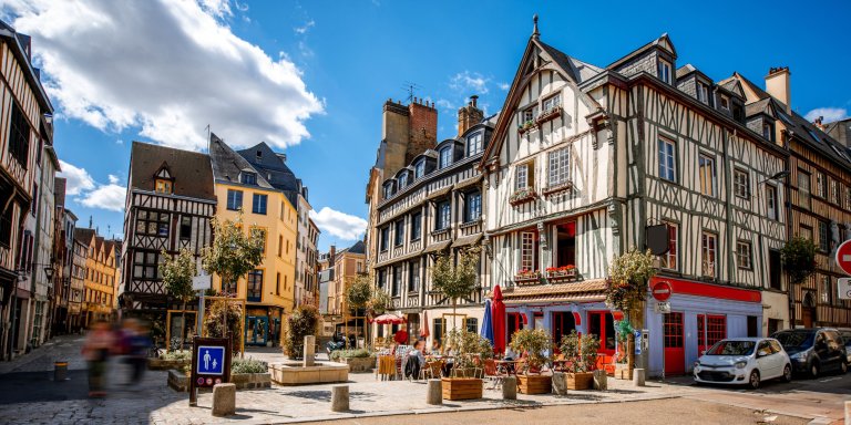 A colourful street in Rouen, adorned with numerous traditional buildings.